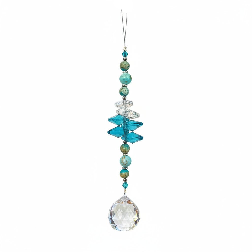 A beaded crystal suncatcher ornament with turquoise, blue, and iridescent beads, hanging on a wooden floor.