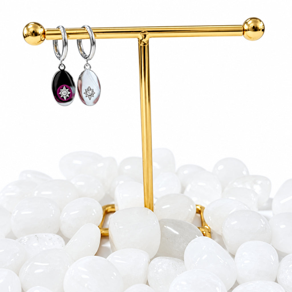 Gold earring stand with earrings on a white background