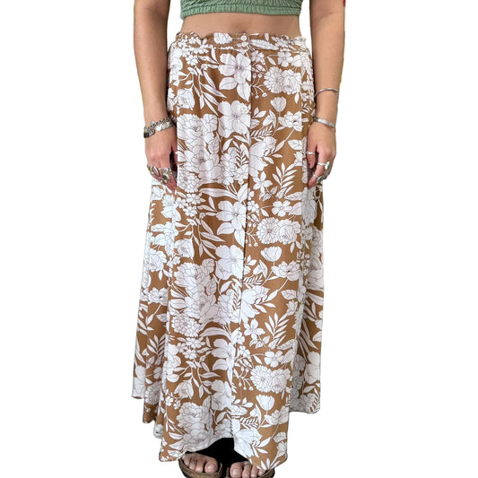 Person wearing a floral skirt in a store with plants and decor