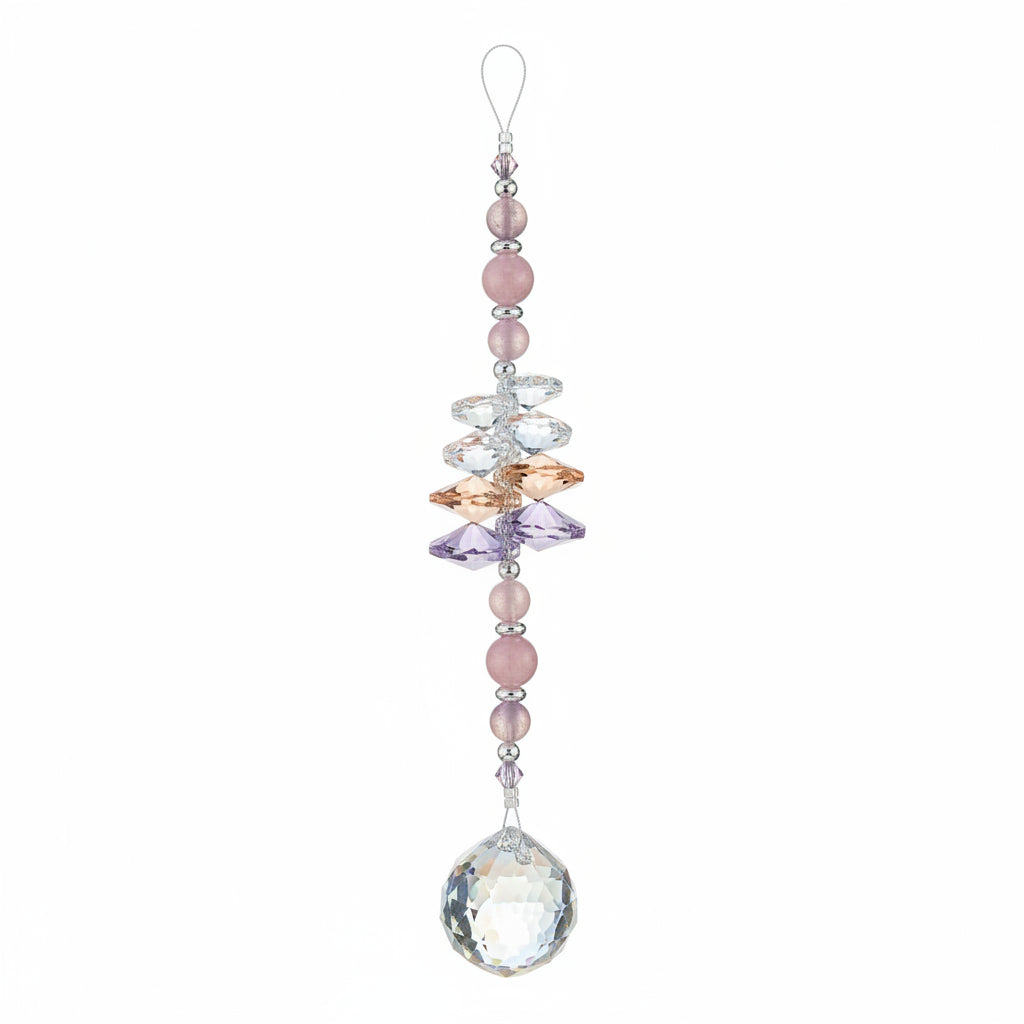 A beaded suncatcher ornament with a large faceted iridescent crystal ball at the bottom, hanging from a purple retail tag on a wooden floor.