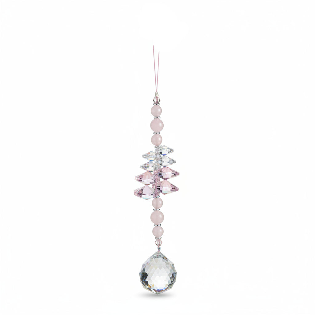A beaded crystal wind chime ornament with white and iridescent beads, hanging on a wooden surface. The top tag reads 'Breathe.