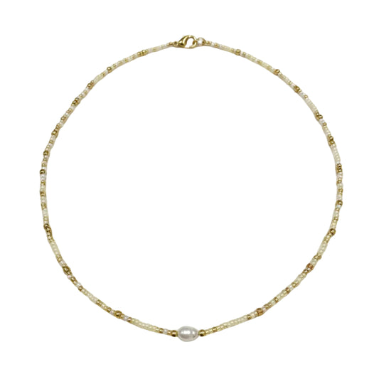 Gold necklace with a pearl pendant worn by a person.