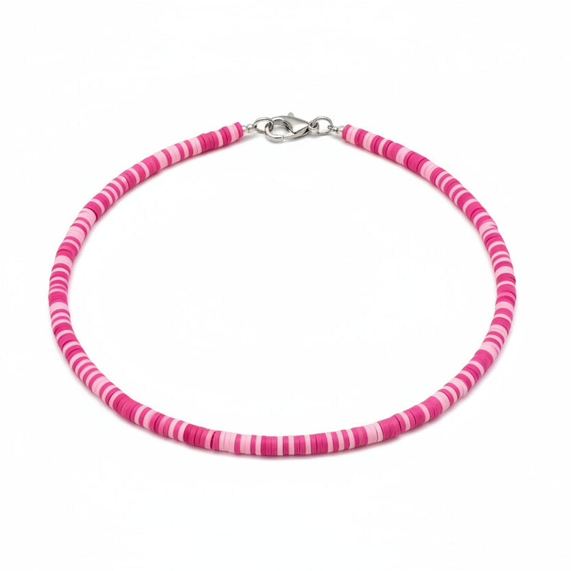Person wearing a pink beaded necklace against a blurred background