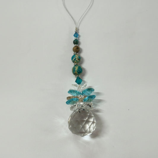Decorative hanging ornament with beads and a large crystal-like bead on a white background.