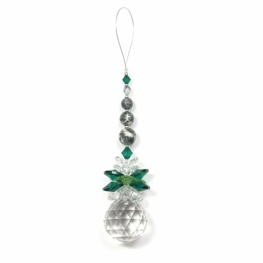 Crystal ornament with green accents on a white background