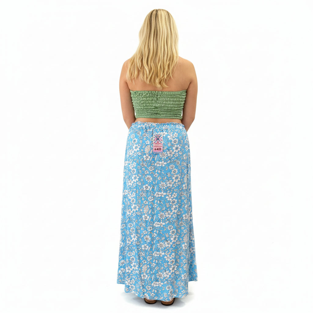 Person wearing a green strapless top and blue floral skirt in a store setting.