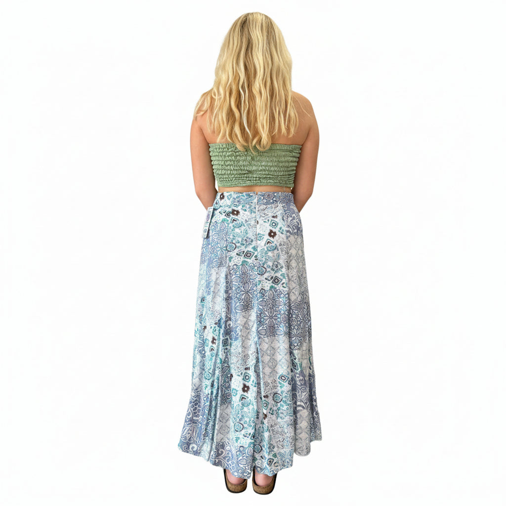 Person wearing a green strapless top and a long, patterned skirt in an indoor setting.
