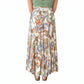 Person wearing a green top and colorful paisley skirt in a store setting with plants and decor.