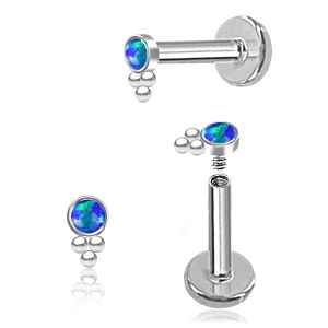 Pair of silver lip piercings with blue gemstones on a white background