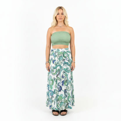 Person wearing a green top and patterned skirt in a store setting