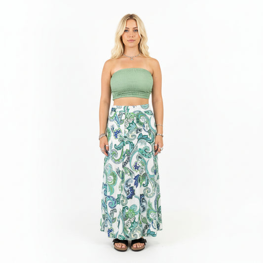 Person wearing a green top and patterned skirt in a store setting